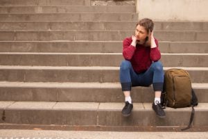 A young woman sits alone on the steps.