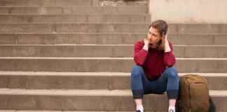 A young woman sits alone on the steps.